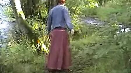 Olgun bir teşhirci kadın nehir kenarında kendini tatmin ediyor