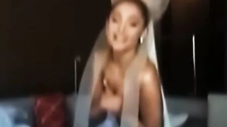 Ariana Grande, kamera arkasında üstsüz bir şekilde göğüslerini tutuyor